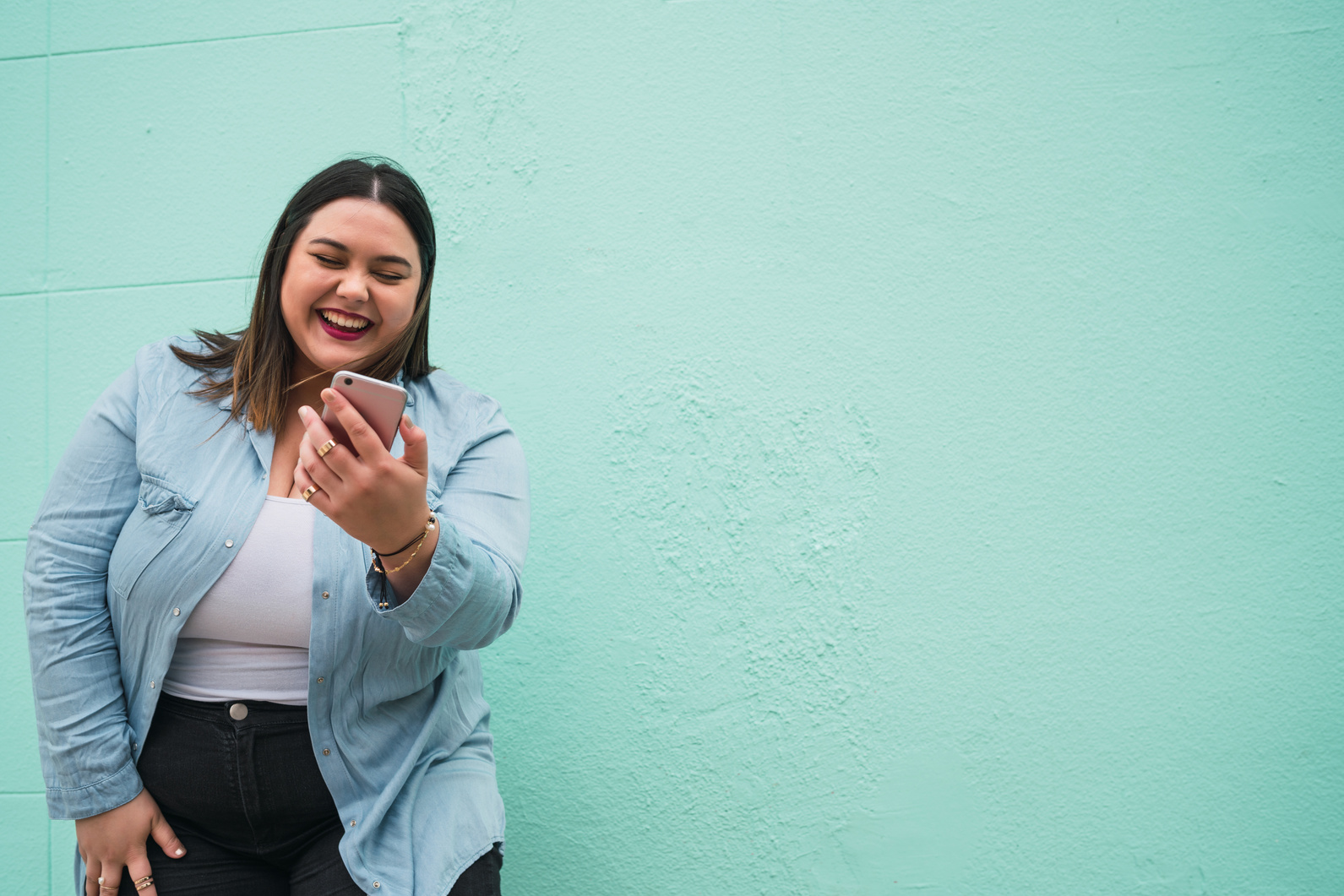 Laughing Plus Size Woman Looking at Smartphone 