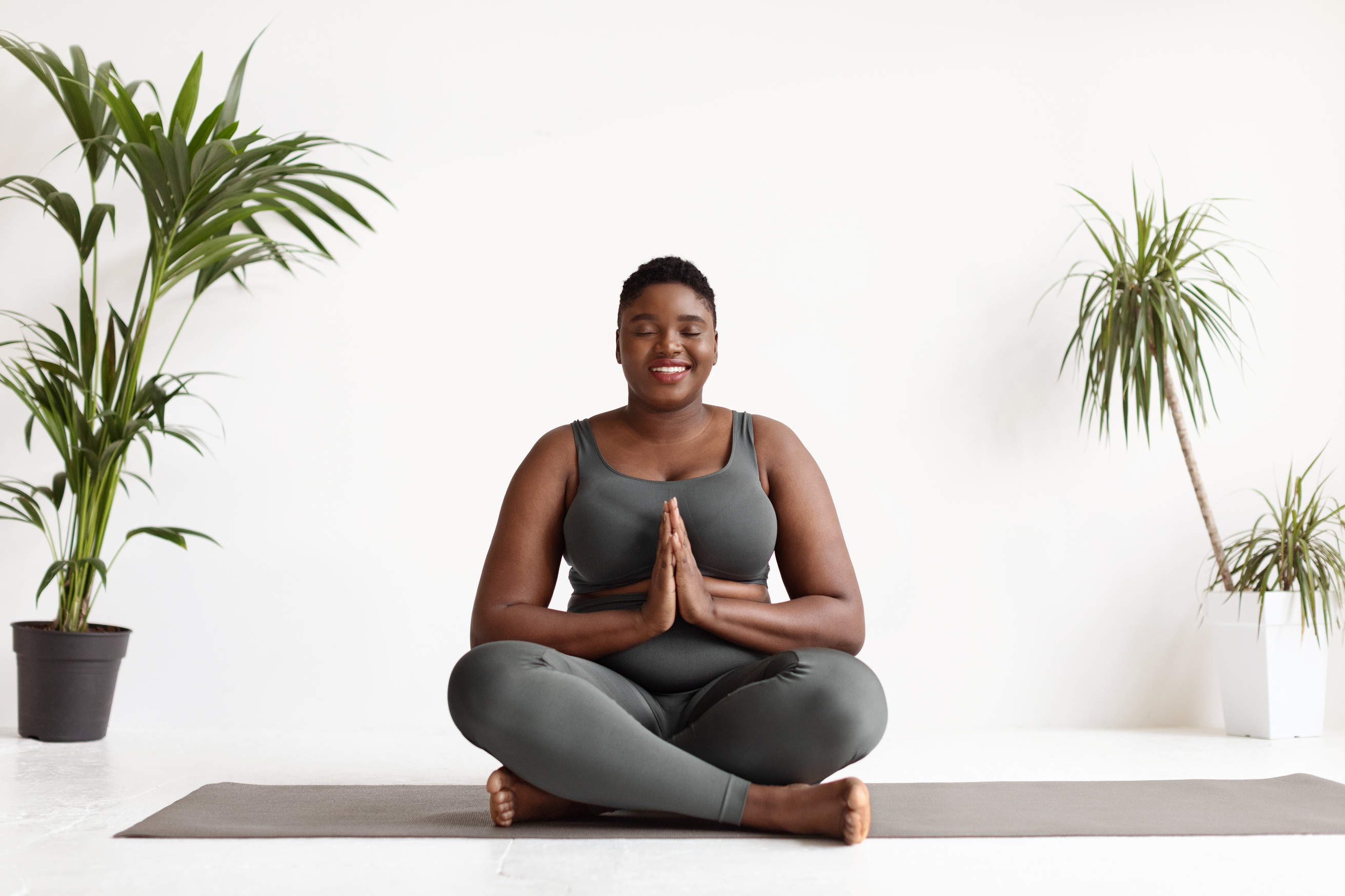 Plus Size Woman Meditating on a Yoga Mat 